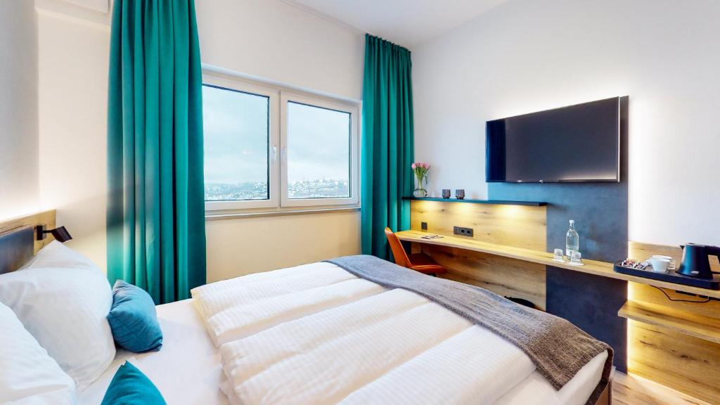 ein Hotelzimmer mit einem Bett und einem TV in der Unterkunft Point 7 Hotel in Fulda