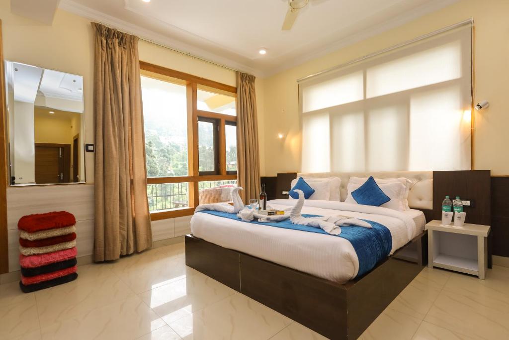 1 dormitorio con 1 cama grande y toallas. en Hotel yellow nest inn, en Dharamshala