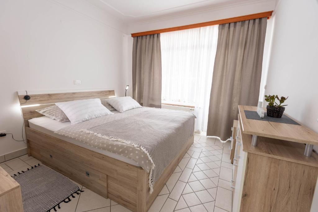 um quarto com uma cama grande e uma janela em Apartmaji Natura KOLPA em Adlešiči