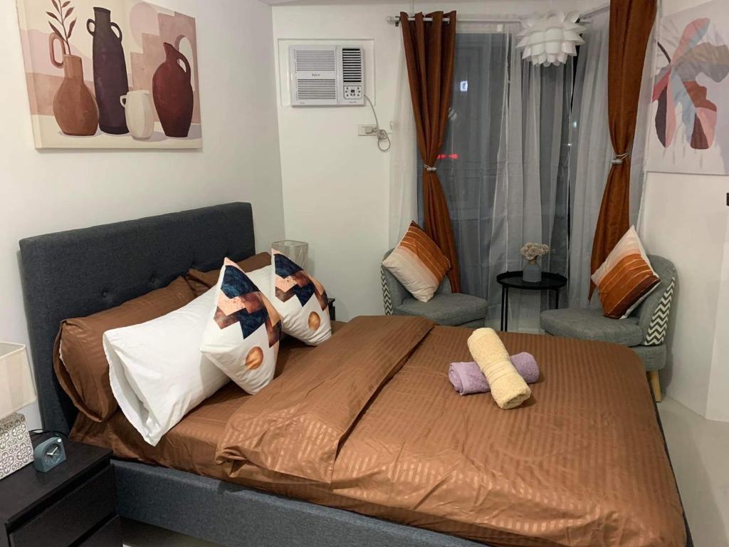 una camera da letto con un letto con cuscini sopra di Comfy Condo Grand Riviera Suite, Roxas Blvd Ermita Manila infront of US Embassy a Manila