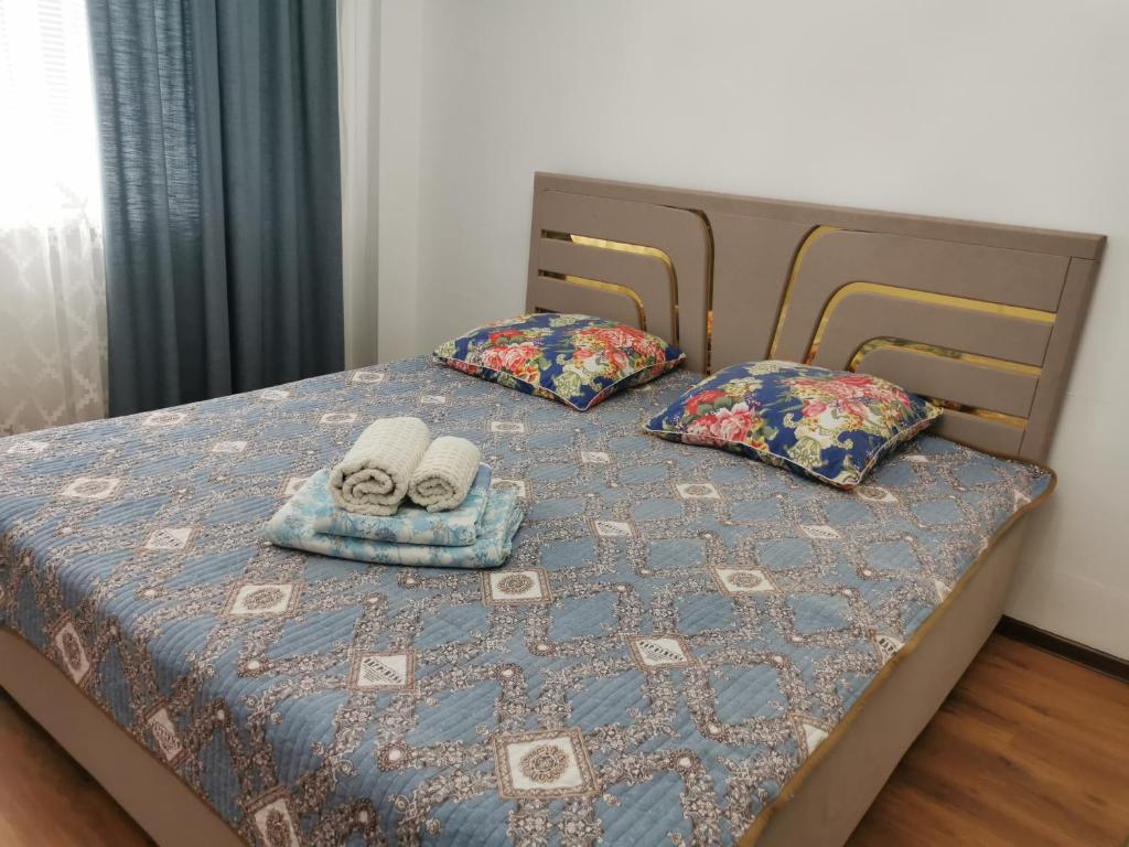 阿特勞的住宿－Квартира，一张带两条毛巾和两个枕头的床