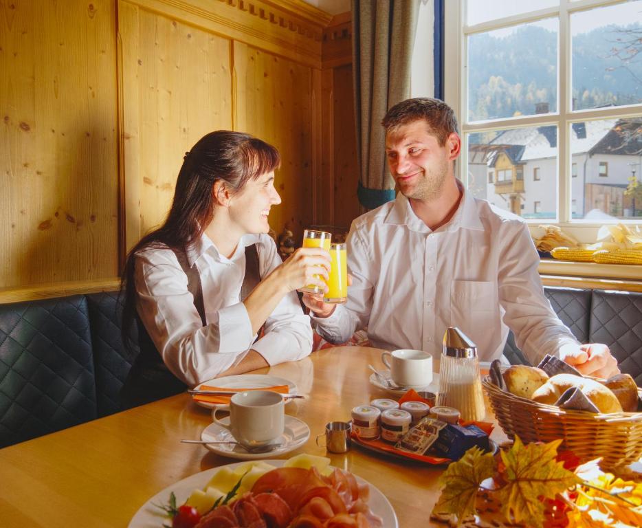 a man and woman sitting at a table with food at Gasthof zum Postwirt in Predlitz