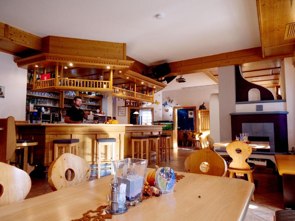 a man in a kitchen with a table and chairs at Gasthof zum Postwirt in Predlitz