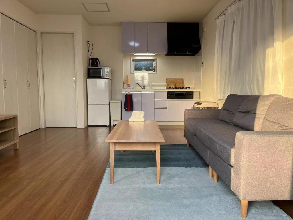 ein Wohnzimmer mit einem Sofa und einem Tisch in der Unterkunft Methodnet Hanazono B / Vacation STAY 77522 in Chiba
