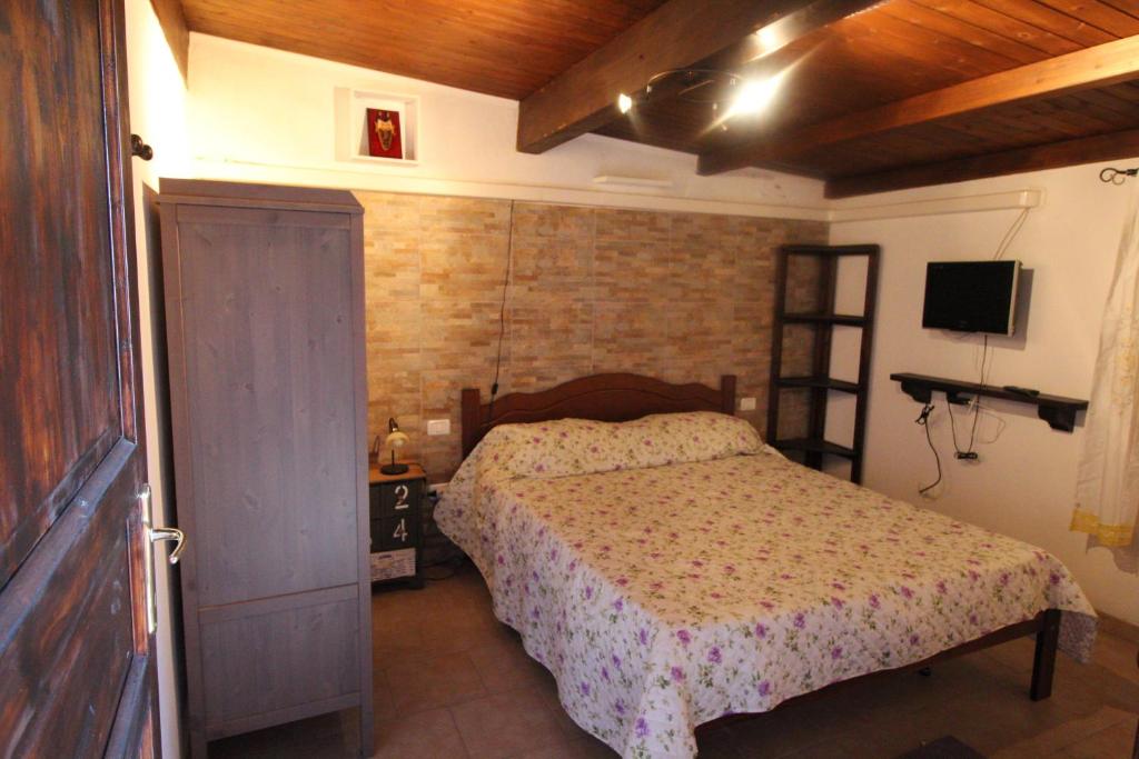 - une chambre avec un lit et une télévision dans l'établissement la terrazza, à Quartu SantʼElena