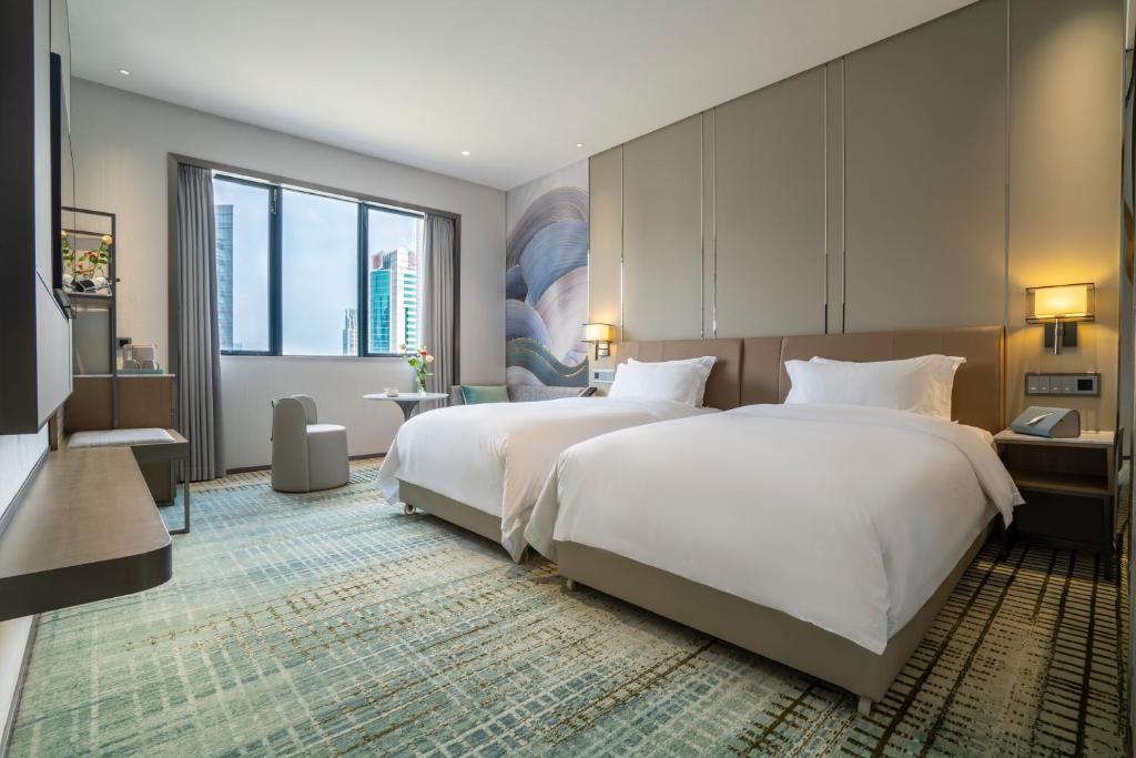 廣州的住宿－广州维多利酒店，酒店客房设有两张床和大窗户。