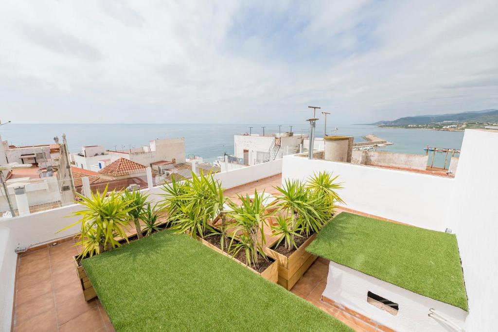 een balkon met groen gras en uitzicht op de oceaan bij atico en el centro del castillo CASA KIKO in Peñíscola