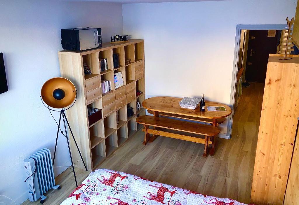 a room with a table and a book shelf at Studio au pied des pistes in Villard-de-Lans