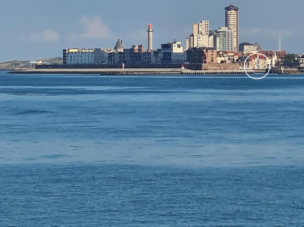 a large body of water with a city in the background at Rijksmonument Havenzicht, met zeezicht, ligging direct aan zee en centrum in Vlissingen