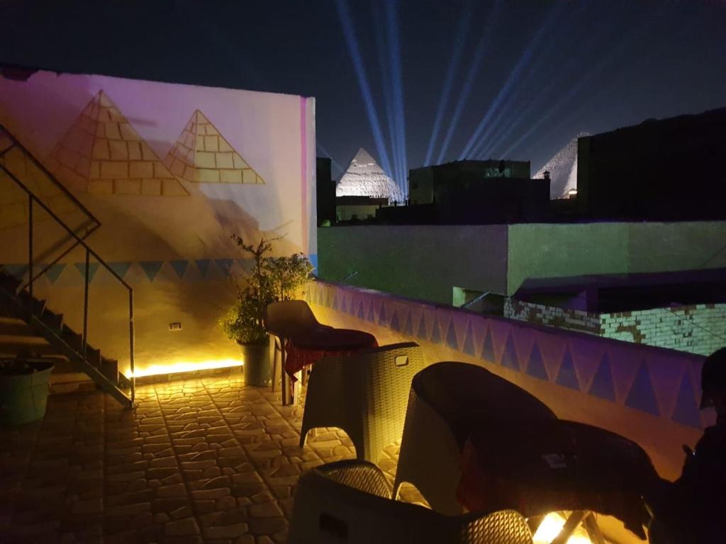 Jana Pyramids view inn في القاهرة: غرفة بها كراسي وجدار به أضواء