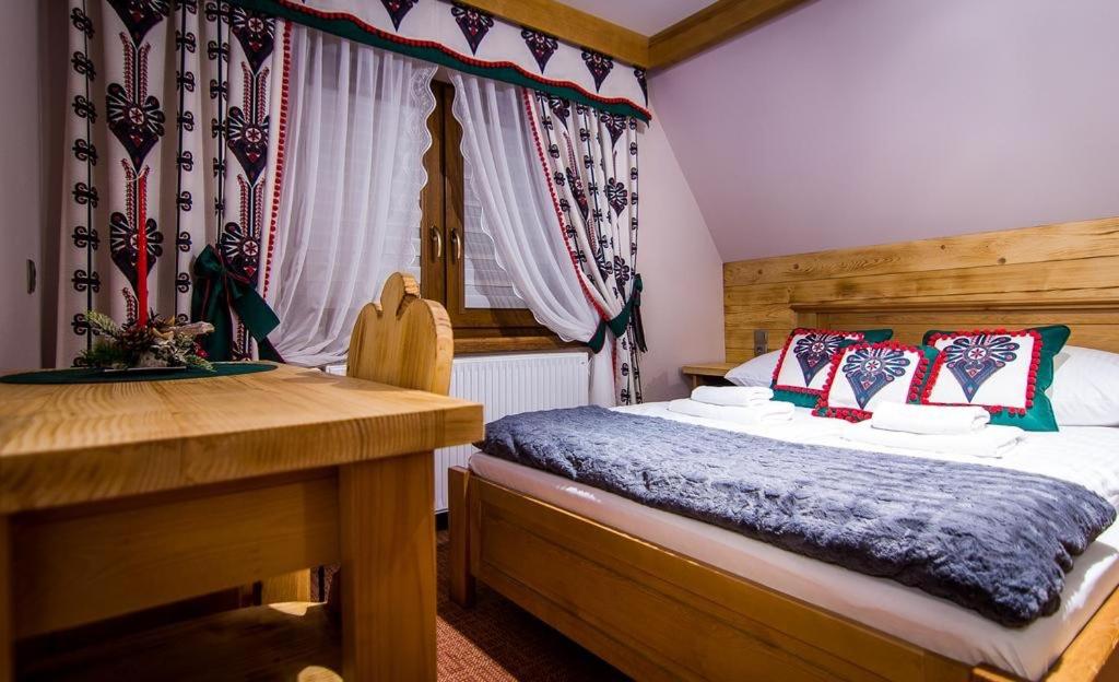 a bedroom with a bed and a desk in a room at Apartamenty u Stopków in Biały Dunajec