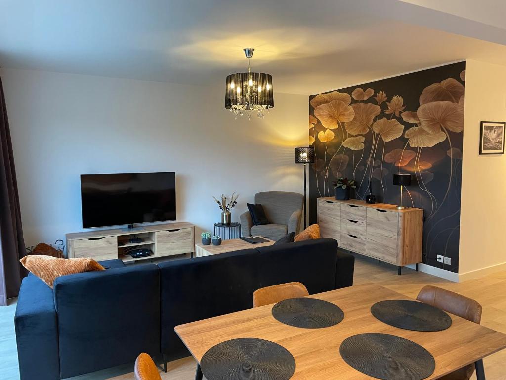 un soggiorno con divano blu e TV di Q Geraardsbergen a Geraardsbergen