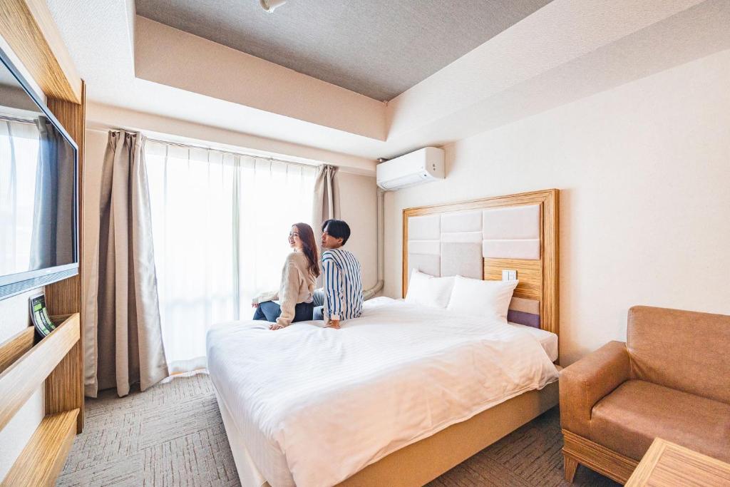 Postel nebo postele na pokoji v ubytování HOTEL RELIEF Namba Daikokuchou
