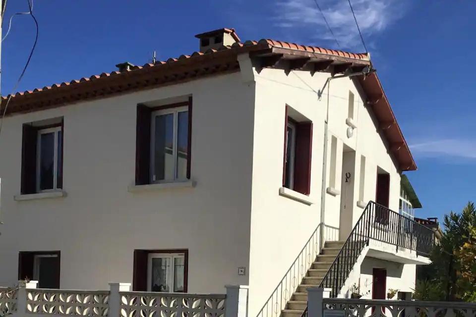 a white house with stairs on the side of it at L olivier in Prades