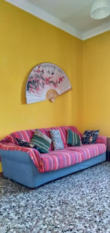 um sofá rosa num quarto com uma parede amarela em Il Cortile em Brugherio