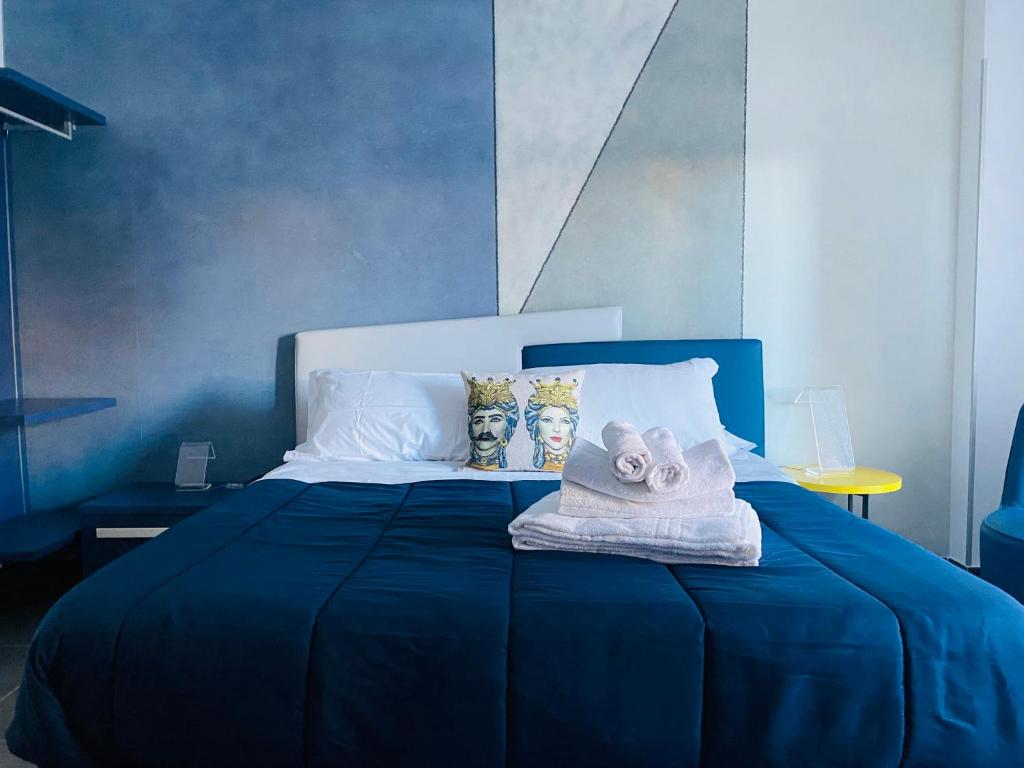 een blauw bed met handdoeken erop bij I Cinque Mori DEVA in Siracusa