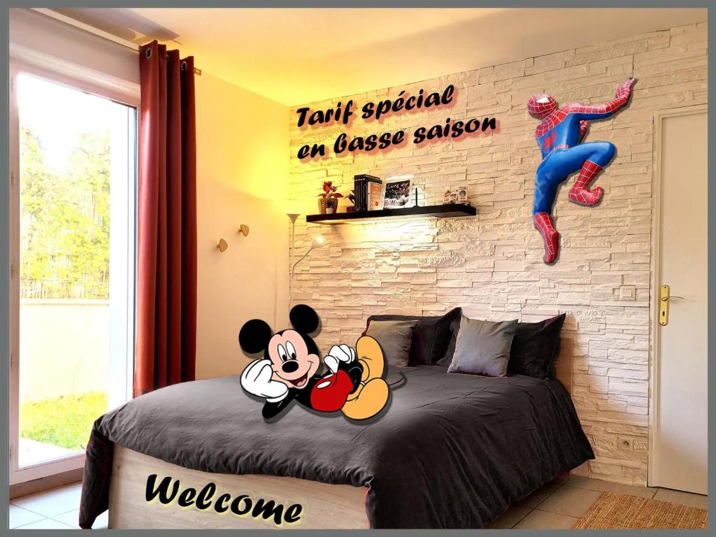 a bedroom with a mickey mouse sign on a bed at Salle de jeux enfant 10min de disney transport en commun 1 chambre 4 couchages et 2 dans le salon in Chanteloup-en-Brie