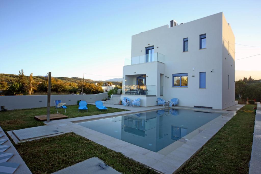 a villa with a swimming pool in front of a house at Ciel Villa in Kalyves