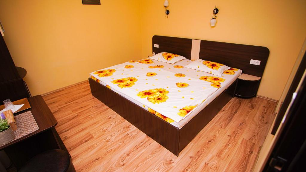 ein Schlafzimmer mit einem Bett mit Blumen darauf in der Unterkunft Pensiunea mălin și răzvan (chillbrothers) in Baile Felix