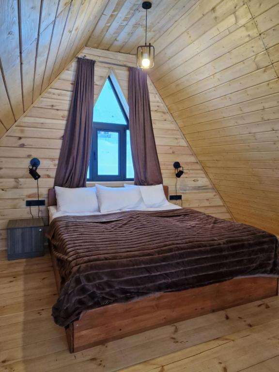 1 dormitorio con 1 cama grande en el ático en Kera cottages kazbegi, en Kazbegi