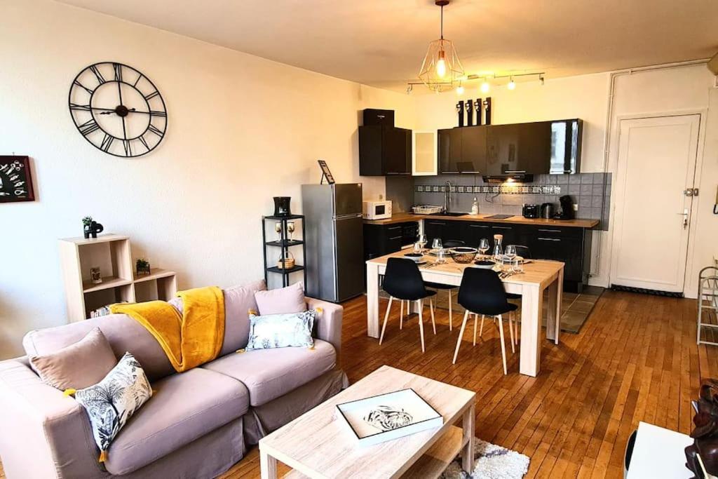 un salon avec un canapé et une table et une cuisine dans l'établissement My Conciergerie by Lucy Violin - Le Gambetta, à Angoulême
