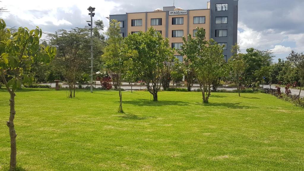 a park with trees in front of a building at Peaks Hotel Nanyuki in Nanyuki