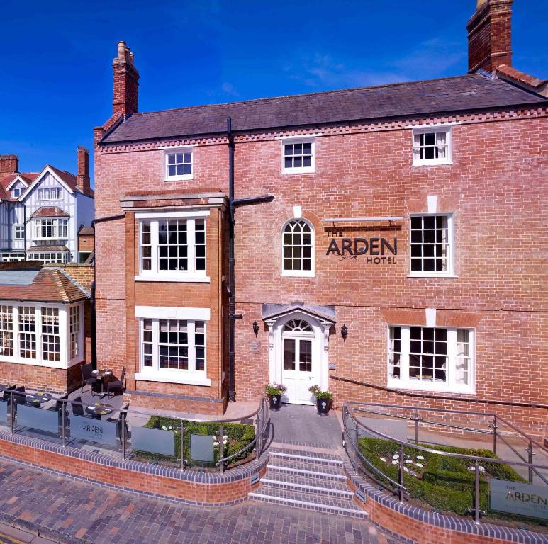 a red brick building with a sign on it at The Arden Hotel Stratford - Eden Hotel Collection in Stratford-upon-Avon