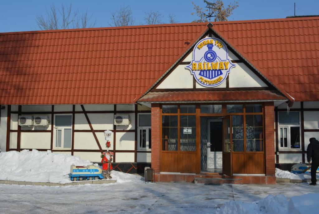 a building with a sign on the front of it at Railway Hotel in Almaty