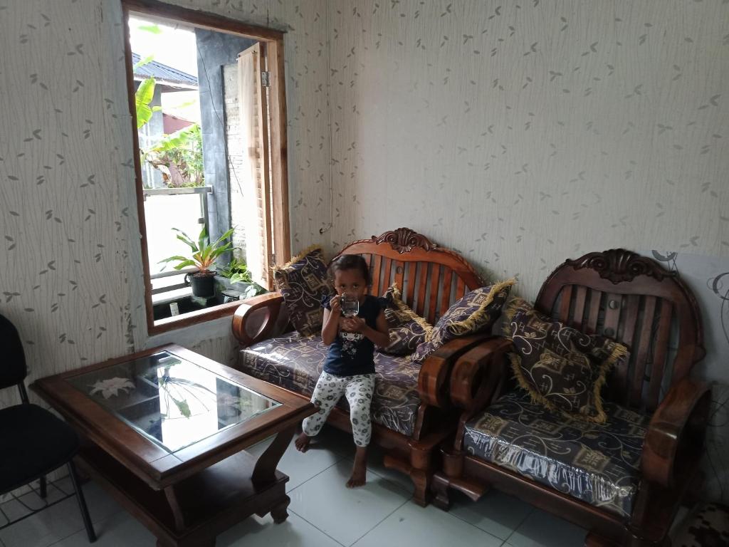 a little boy sitting on a couch taking a picture at Mutiara Dieng in Wonosobo