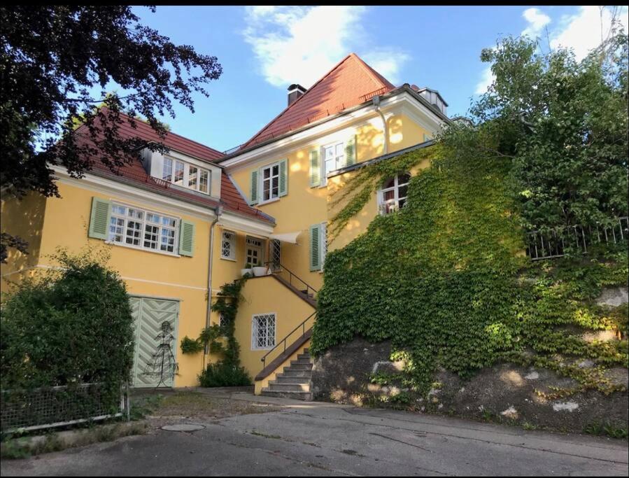 a yellow house with a staircase in front of it at Romantischer Villenteil in der Barock- und Musikstadt Ochsenhausen in Ochsenhausen