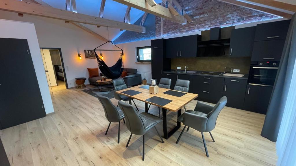 a kitchen and dining room with a table and chairs at H-Loft Style Apartments in Bad Lauterberg
