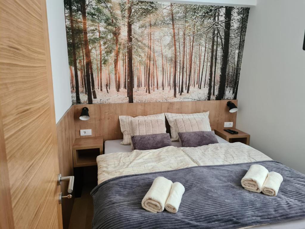 una camera con due letti e un dipinto di una foresta di VilaJahor Natasa A11 a Jahorina