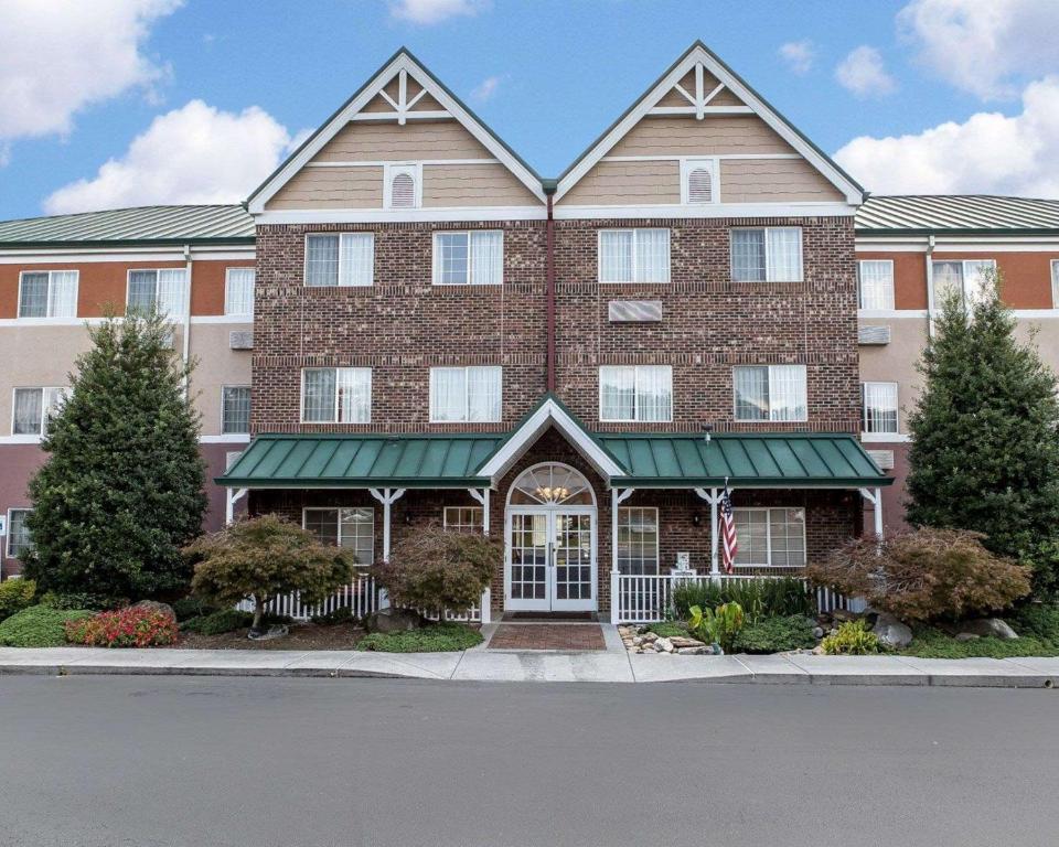 a large brick building with a green awning at MainStay Suites Knoxville Airport in Alcoa