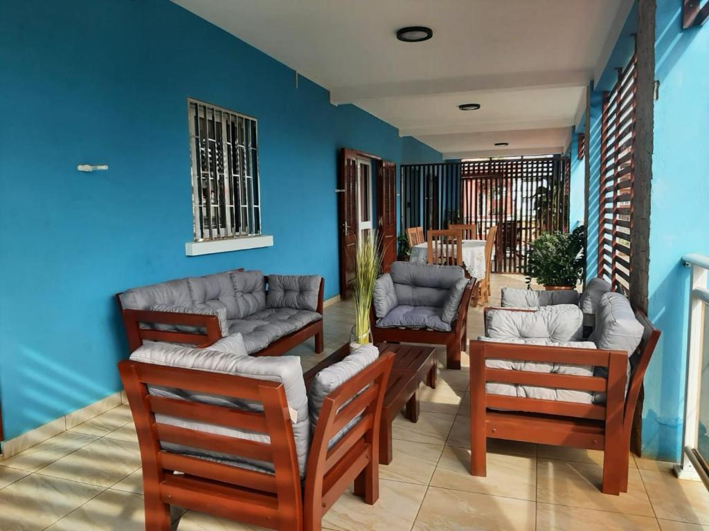 迪亞戈蘇阿雷斯的住宿－Résidence Beyt Salama - T1bis ou T4，一间带椅子和沙发的房间以及一面蓝色的墙壁