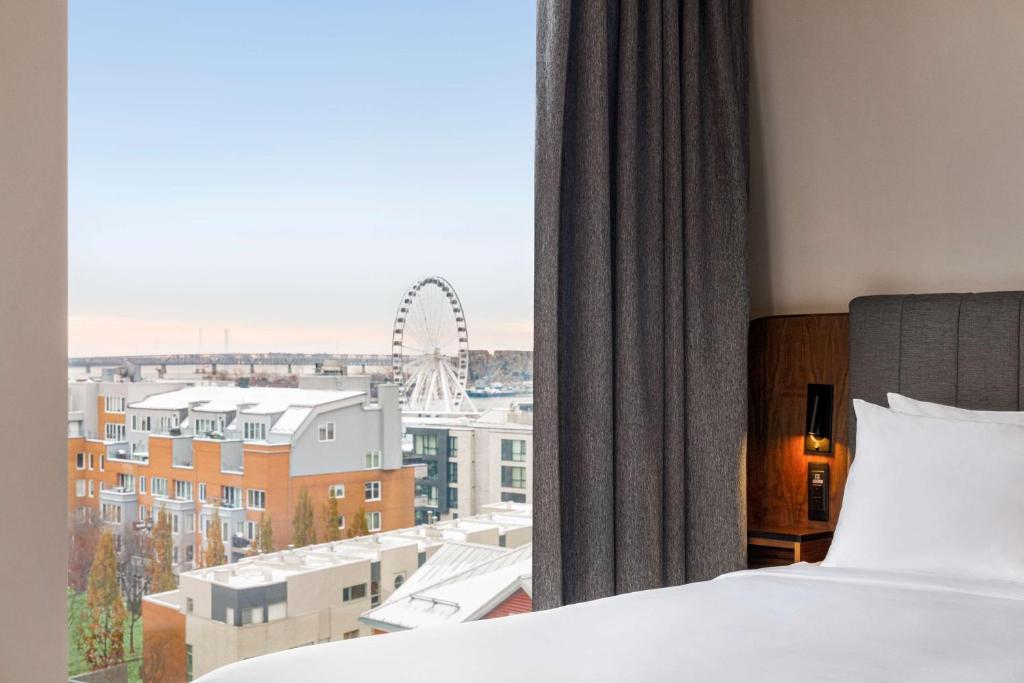 ein Schlafzimmer mit einem Bett und einem Fenster mit einem Riesenrad in der Unterkunft Hyatt Centric Montreal in Montreal