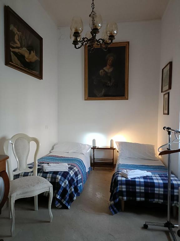 a bedroom with two beds and a chandelier at Mavipagi in Verona