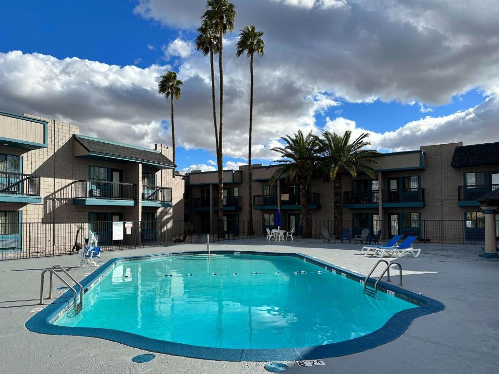 a large swimming pool in a courtyard with palm trees at Mesa AZ Near Downtown & Sloan Park in Mesa