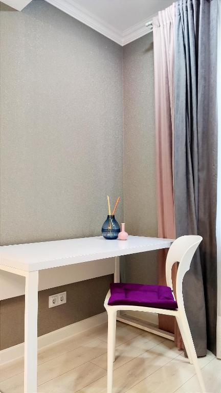 a white desk with a purple stool under it at 1BR ultracentral Chișinău in Chişinău