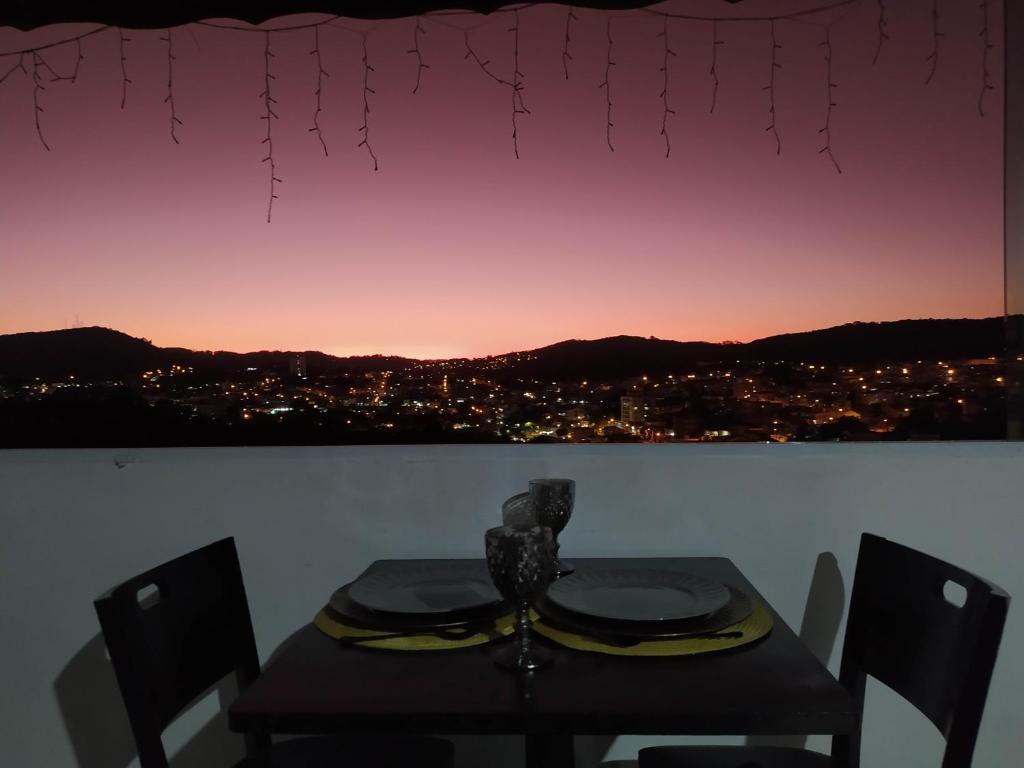 a dining room table with a view of a city at Apartamento Por do Sol - Cobertura in São Roque