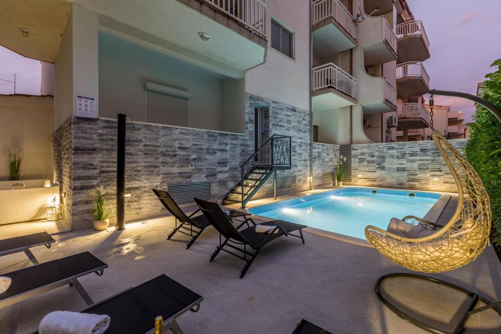 a patio with a hammock and a swimming pool at Holiday apartments Stobrec in Split