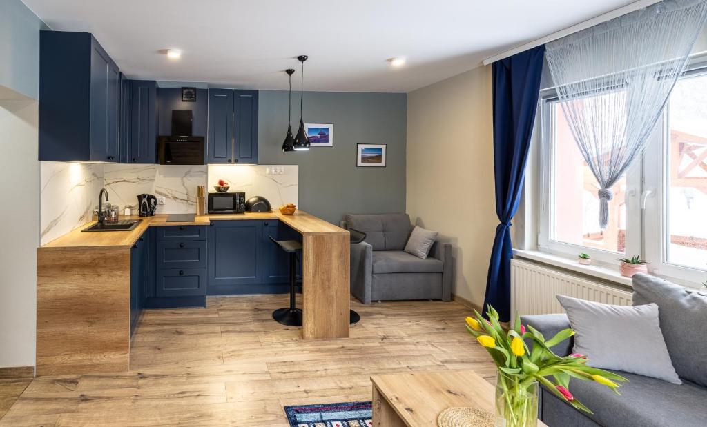 a kitchen and living room with blue cabinets at Apartament Sarenka in Szklarska Poręba