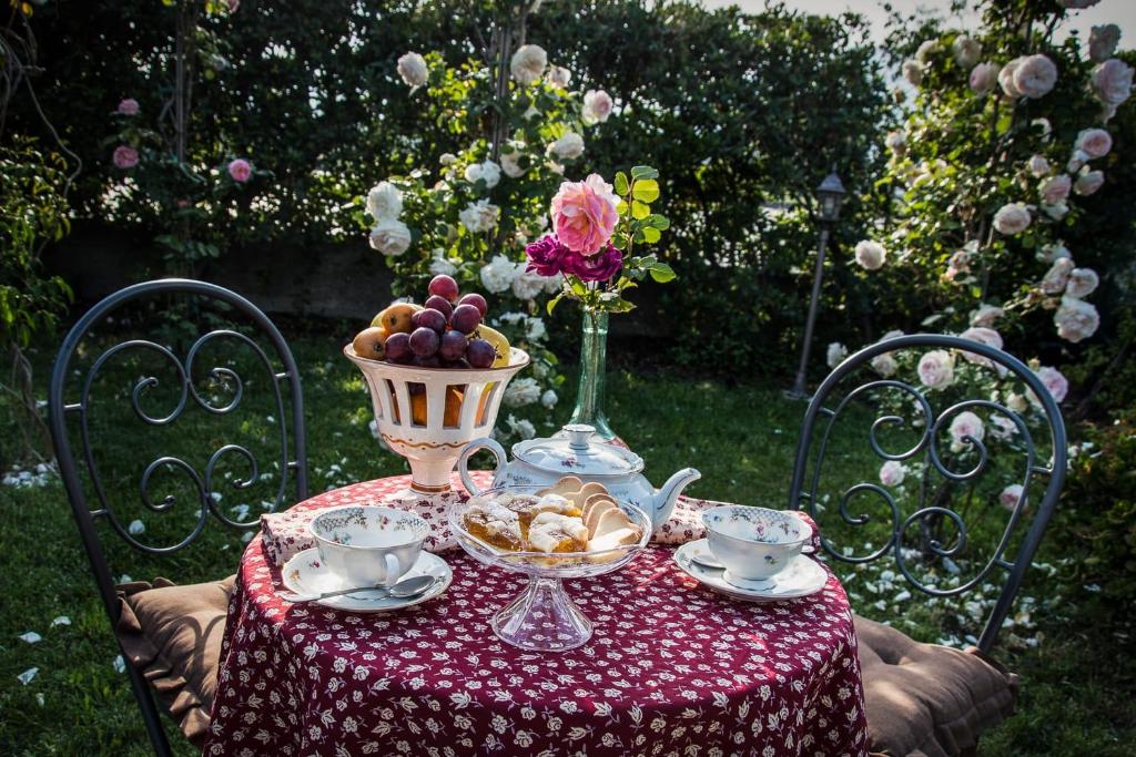 una mesa con un bol de fruta y un jarrón de flores en B&B Del Tempo Stretto, en Albenga