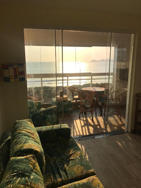 sala de estar con sofá y balcón con mesa en Melhor vista para o mar, en Penha