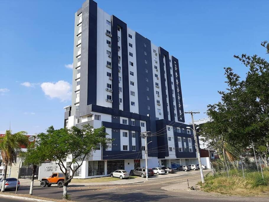 a large blue and white building on a street at Confortable y Moderno Studio in Santa Cruz de la Sierra