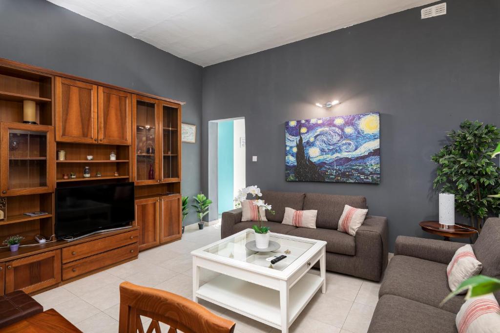 a living room with a couch and a tv at 1 Bedroom Apartment with cosy Backyard close to Valletta in Il-Furjana