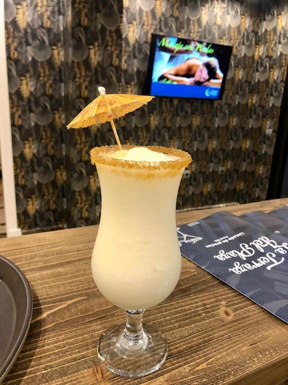 a drink sitting on a table with an umbrella at Hotel Spa Cádiz Plaza in Cádiz