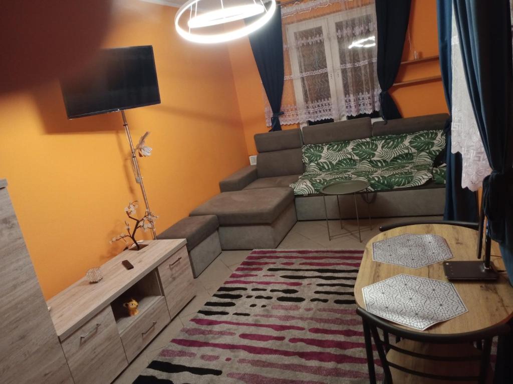 una pequeña sala de estar con sofá y mesa. en Uroczy Apartament, en Cracovia