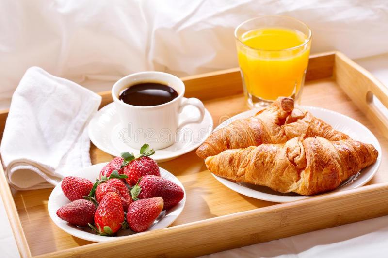 - un plateau avec des fraises, des croissants et une tasse de jus d'orange dans l'établissement Hôtel Provençal, à Dakar
