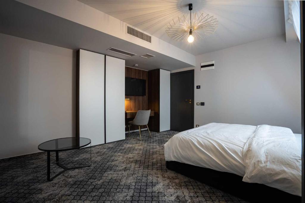 Hotel Cristal في كلوي نابوكا: غرفة نوم فيها سرير وطاولة فيها