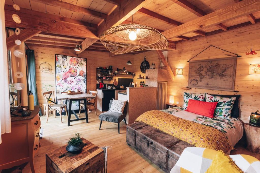 a bedroom with a bed and a desk and a kitchen at La cabane du bon chemin ,spa in Laval